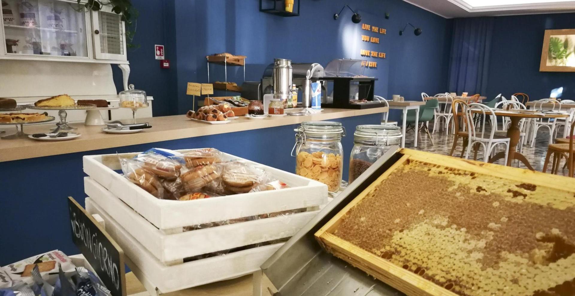 Buffet colazione con dolci, miele e biscotti in un ambiente accogliente.