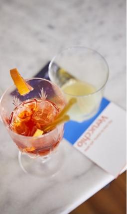 Due cocktail su un tavolo di marmo con un tovagliolo blu e bianco.