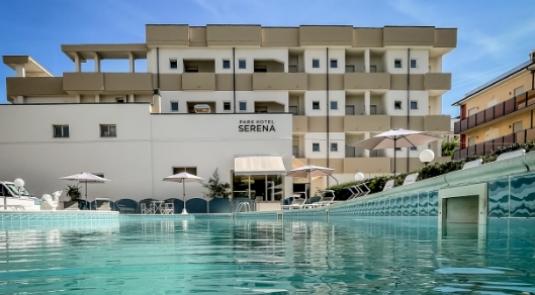 Hotel con piscina all'aperto, ombrelloni e lettini per il relax.