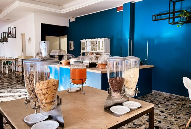 Buffet con cereali e succhi in una sala da pranzo moderna e luminosa.