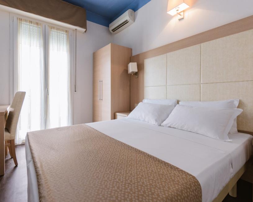 Camera da letto moderna con letto matrimoniale, armadio e aria condizionata.