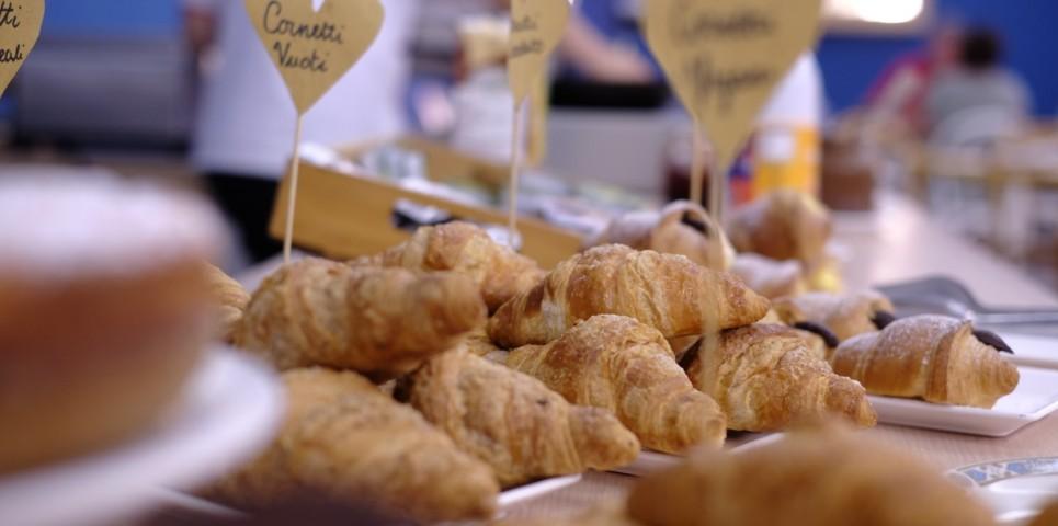 Croissant freschi su un tavolo, con etichette che indicano i diversi ripieni.